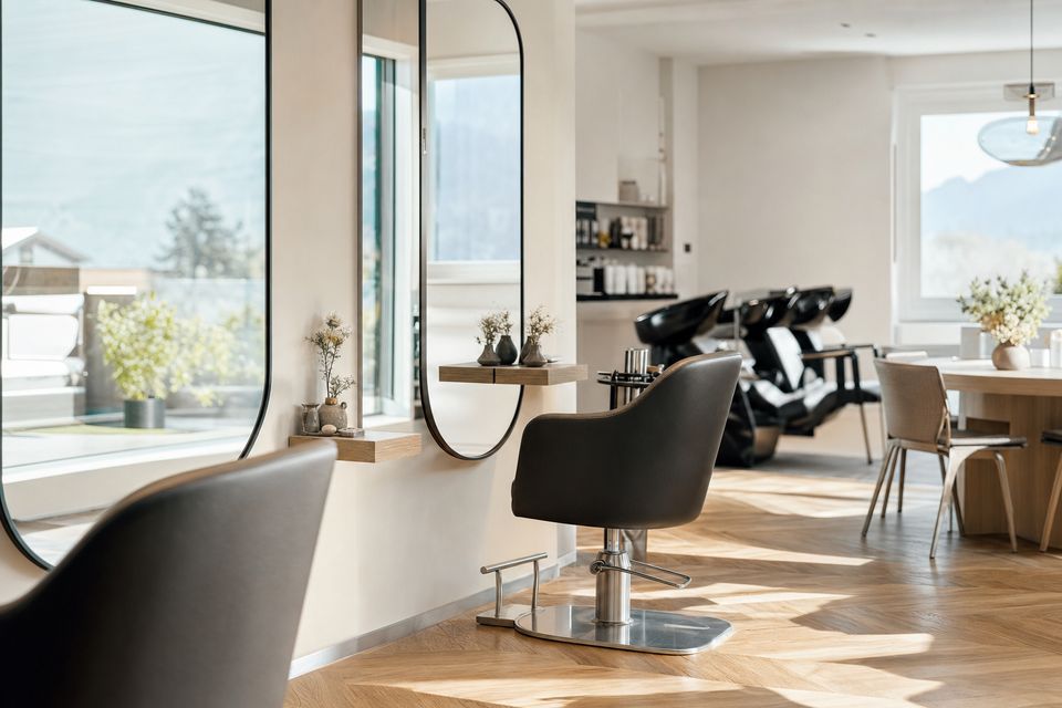Helles Stimmungsbild des Salons: klare Linien, viel Weißraum und Tageslicht durch ein großes Fenster